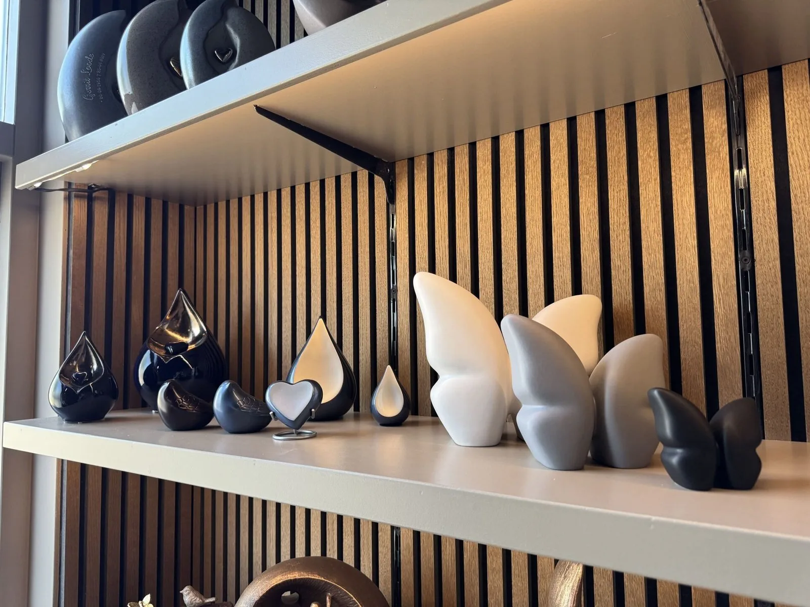 Wandschappen in de showroom met urnen in verschillende vormen en kleuren